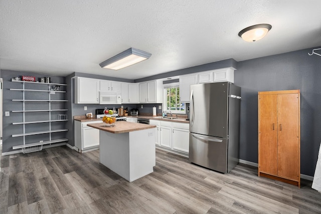 400 Mill St, Loyal, WI 54446 - kitchen featuring freestanding refrigerator, white microwave, stove, white cabinets, and a textured ceiling