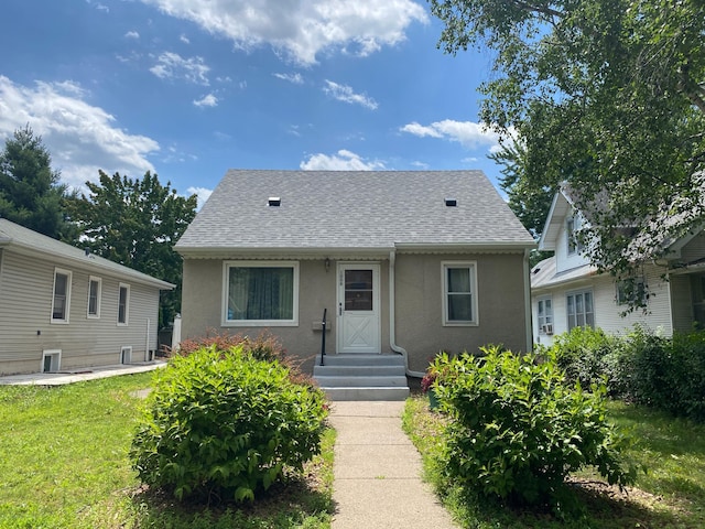1008 Hawthorne Ave E, Saint Paul, MN 55106 - bungalow with stucco siding, a shingled roof, and a front yard