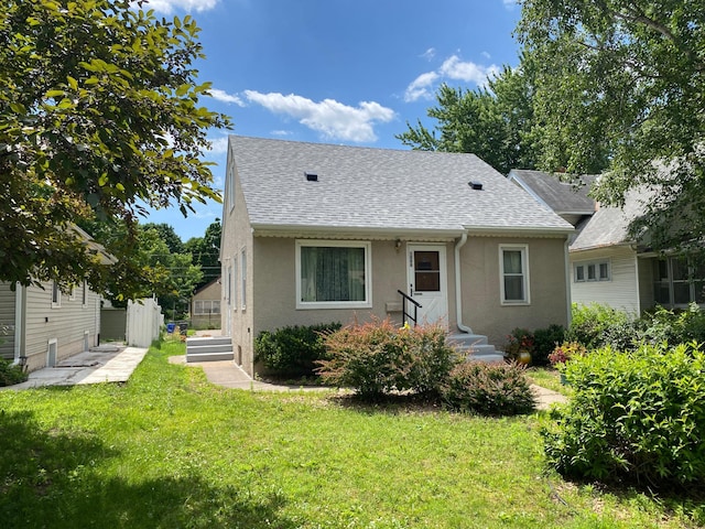 1008 Hawthorne Ave E, Saint Paul, MN 55106 - rear view of house with stucco siding, roof with shingles, and a yard