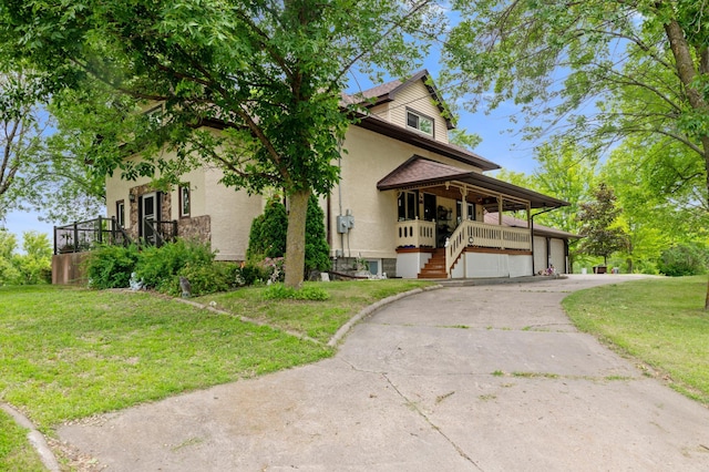 9691 Kadler Ave NE, Otsego, MN 55362 - view of front of home featuring a garage, a front lawn, driveway, stucco siding, and a porch