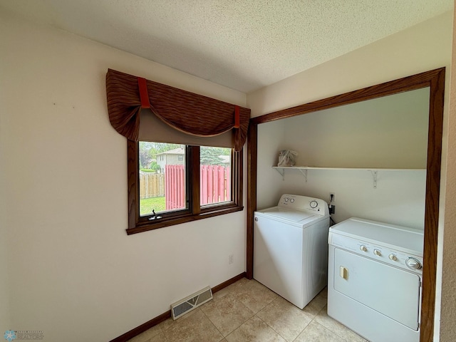 2602 Eastgate Dr S, Fargo, ND 58103 - laundry area featuring separate washer and dryer, light tile patterned floors, and a textured ceiling