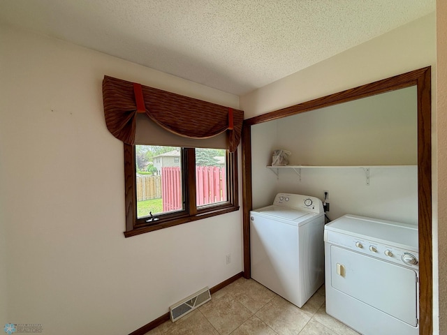 2602 Eastgate Dr S, Fargo, ND 58103 - laundry room featuring separate washer and dryer, light tile patterned floors, and a textured ceiling