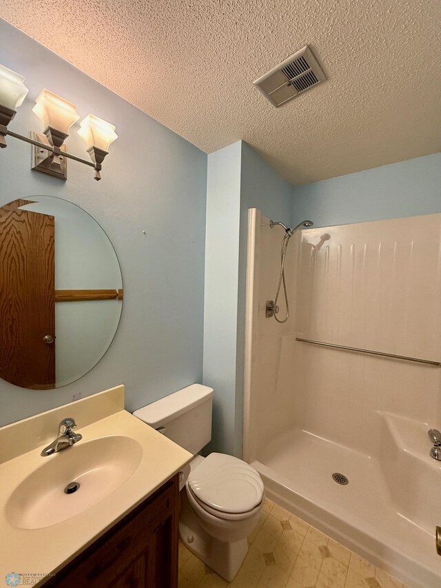 2602 Eastgate Dr S, Fargo, ND 58103 - bathroom with a textured ceiling, vanity, and a shower
