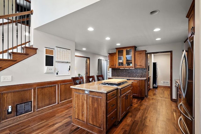4407 Curve Ave, Edina, MN 55424 - kitchen featuring appliances with stainless steel finishes, dark wood-style flooring, a center island, glass insert cabinets, and a wainscoted wall