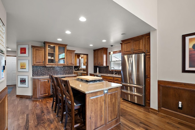 4407 Curve Ave, Edina, MN 55424 - kitchen with appliances with stainless steel finishes, brown cabinets, a center island, dark wood finished floors, and recessed lighting
