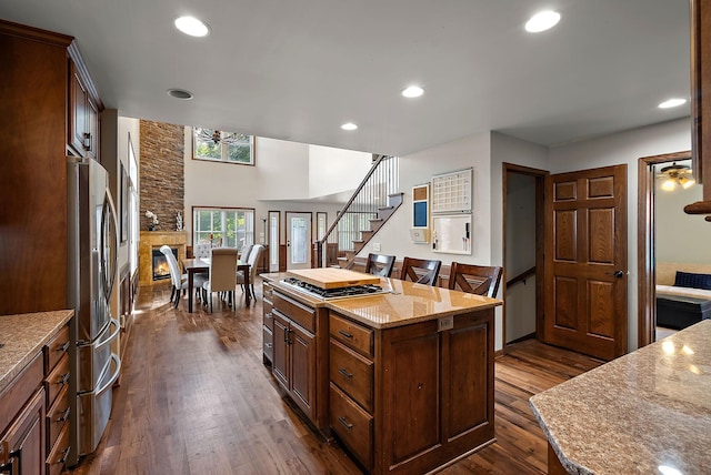 4407 Curve Ave, Edina, MN 55424 - kitchen with dark wood finished floors, freestanding refrigerator, recessed lighting, light stone counters, and a center island