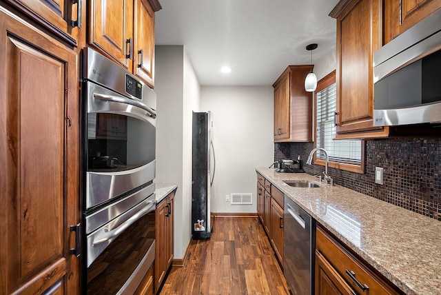 4407 Curve Ave, Edina, MN 55424 - kitchen featuring appliances with stainless steel finishes, decorative backsplash, dark wood-type flooring, brown cabinets, and recessed lighting