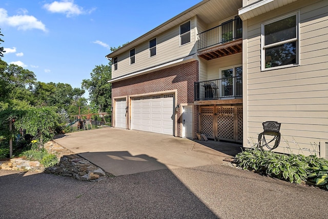 4407 Curve Ave, Edina, MN 55424 - view of side of home featuring a balcony, a garage, driveway, and brick siding