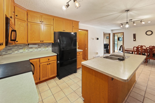 5100 16th St NE, Minden Twp, MN 56379 - kitchen with black appliances, rail lighting, light tile patterned floors, light countertops, and backsplash