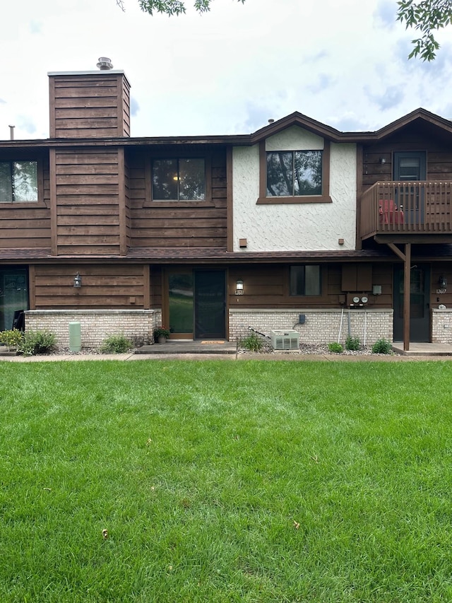 12619 Alder St NW, Coon Rapids, MN 55448 - rear view of property with a chimney, a lawn, a balcony, and brick siding