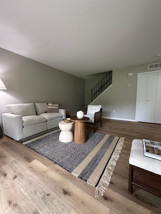 12619 Alder St NW, Coon Rapids, MN 55448 - living room featuring wood finished floors, stairway, and a textured ceiling