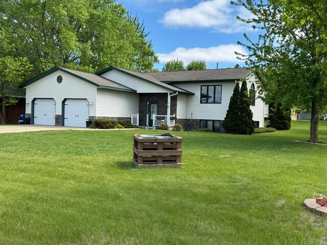 1420 4th St SW, Wadena, MN 56482 - view of front facade featuring a garage, stone siding, a front yard, driveway, and a shingled roof