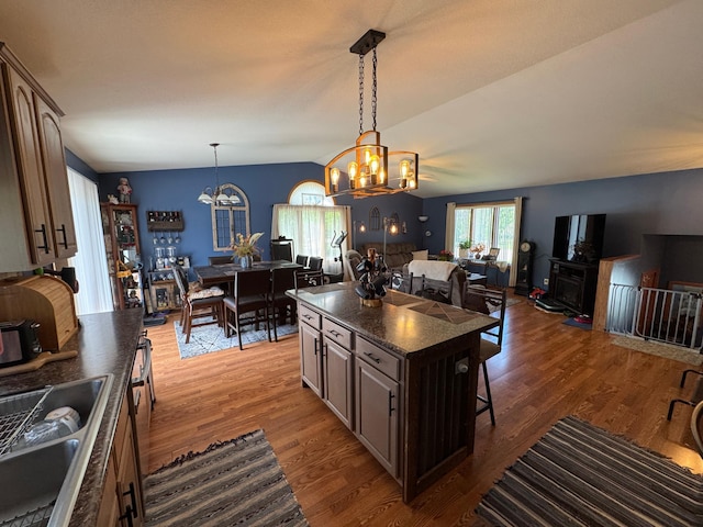 1420 4th St SW, Wadena, MN 56482 - kitchen featuring dark countertops, open floor plan, a chandelier, a kitchen breakfast bar, and pendant lighting