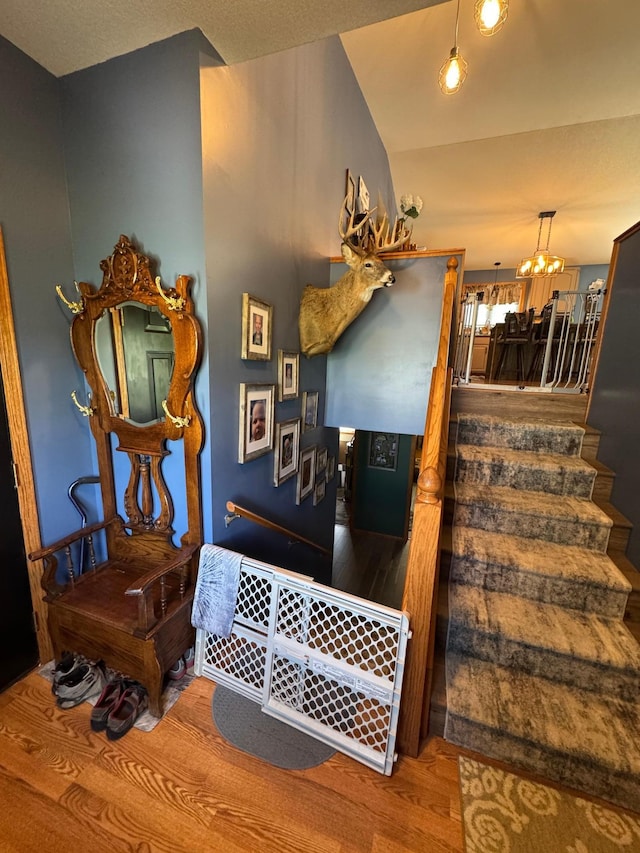1420 4th St SW, Wadena, MN 56482 - stairs with wood finished floors, a chandelier, and lofted ceiling