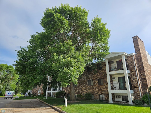 311 Prairiewood Cir S Unit 307, Fargo, ND 58103 - view of front facade with brick siding, a front lawn, a balcony, and a chimney