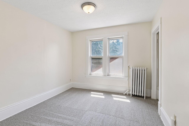 1108 16th Ave SE, Minneapolis, MN 55414 - carpeted empty room featuring radiator and a textured ceiling