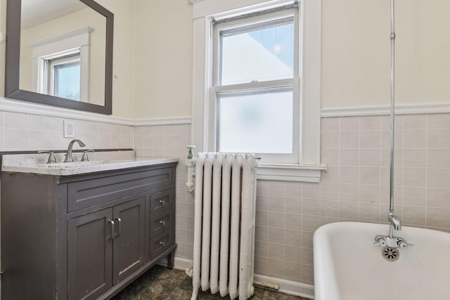 1108 16th Ave SE, Minneapolis, MN 55414 - bathroom with radiator heating unit, tile walls, a freestanding tub, plenty of natural light, and vanity