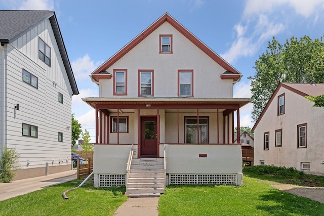 1108 16th Ave SE, Minneapolis, MN 55414 - view of front facade featuring covered porch, a front yard, stucco siding, and board and batten siding