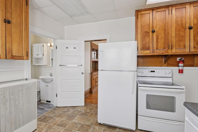 1108 16th Ave SE, Minneapolis, MN 55414 - kitchen featuring white appliances, a drop ceiling, and brown cabinetry