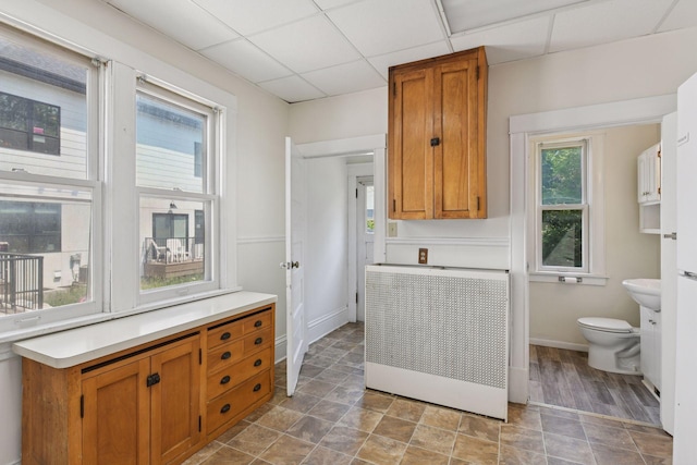 1108 16th Ave SE, Minneapolis, MN 55414 - kitchen featuring a paneled ceiling, brown cabinetry, and light countertops