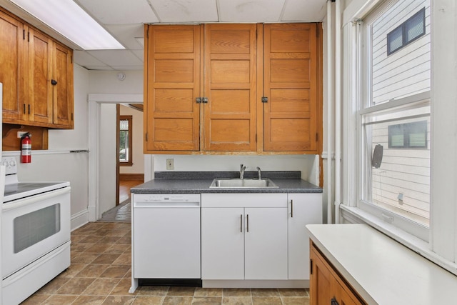 1108 16th Ave SE, Minneapolis, MN 55414 - kitchen featuring white appliances, a paneled ceiling, dark countertops, and brown cabinetry