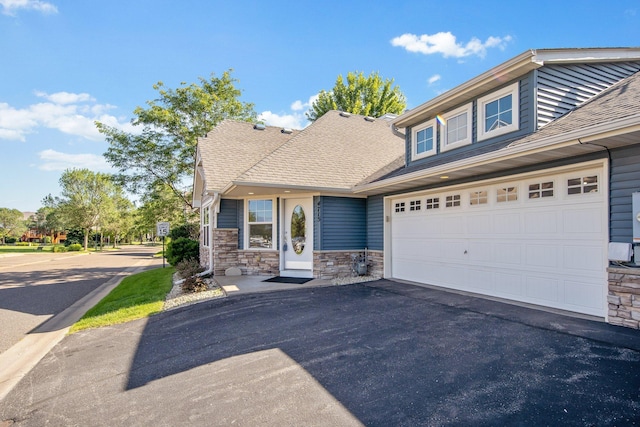 4715 Wyngate Blvd, Forest Lake, MN 55025 - view of front facade with asphalt driveway, stone siding, a shingled roof, and a garage