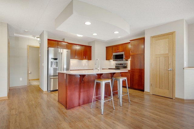 4715 Wyngate Blvd, Forest Lake, MN 55025 - kitchen featuring appliances with stainless steel finishes, light countertops, light wood-type flooring, a breakfast bar, and recessed lighting