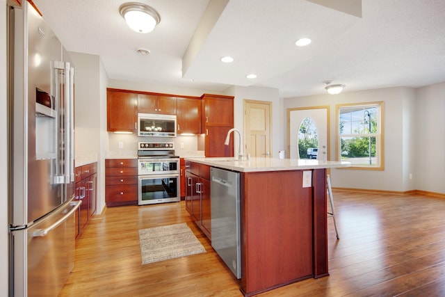 4715 Wyngate Blvd, Forest Lake, MN 55025 - kitchen featuring appliances with stainless steel finishes, light wood-style floors, recessed lighting, a kitchen island with sink, and a breakfast bar