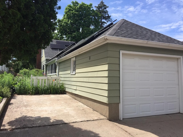 5505 Morgan Ave S, Minneapolis, MN 55419 - view of home's exterior featuring a shingled roof, a garage, roof mounted solar panels, and concrete driveway