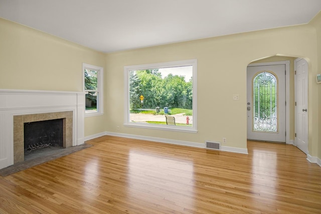 4700 Xerxes Ave N, Minneapolis, MN 55430 - unfurnished living room with light wood-type flooring, arched walkways, and a fireplace