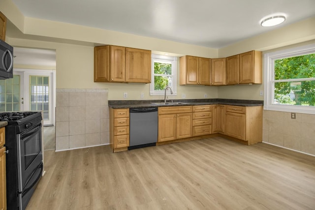 4700 Xerxes Ave N, Minneapolis, MN 55430 - kitchen featuring light wood-style floors, stainless steel dishwasher, dark countertops, plenty of natural light, and tile walls