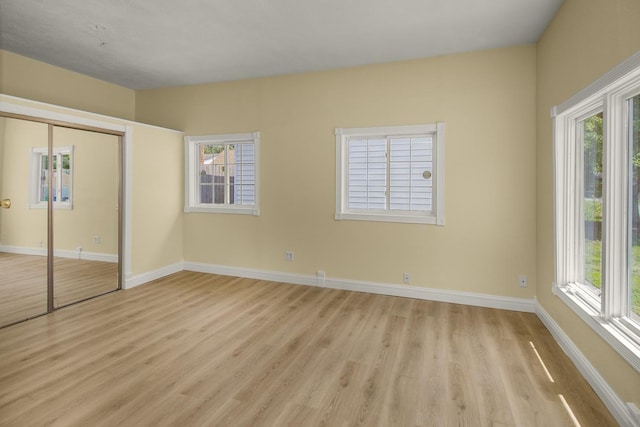 4700 Xerxes Ave N, Minneapolis, MN 55430 - unfurnished bedroom featuring light wood-style floors, multiple windows, and a closet