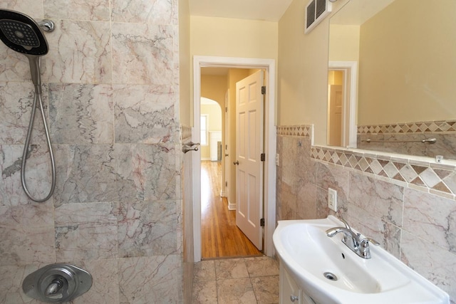 4700 Xerxes Ave N, Minneapolis, MN 55430 - bathroom featuring tile walls, a wainscoted wall, and tiled shower