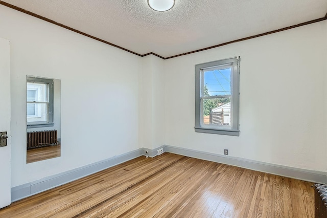 2810 Morgan Ave N, Minneapolis, MN 55411 - unfurnished room with ornamental molding, radiator heating unit, light wood-type flooring, and a textured ceiling