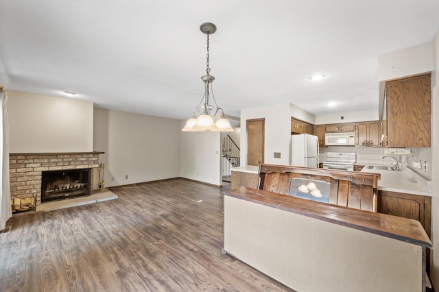 2671 Sumac Rdg, White Bear Lake, MN 55110 - kitchen with white appliances, wood finished floors, decorative light fixtures, brown cabinets, and a fireplace