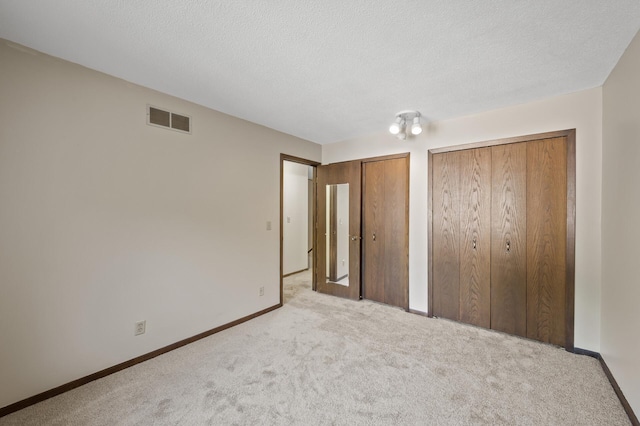 2671 Sumac Rdg, White Bear Lake, MN 55110 - unfurnished bedroom featuring multiple closets, carpet floors, and a textured ceiling