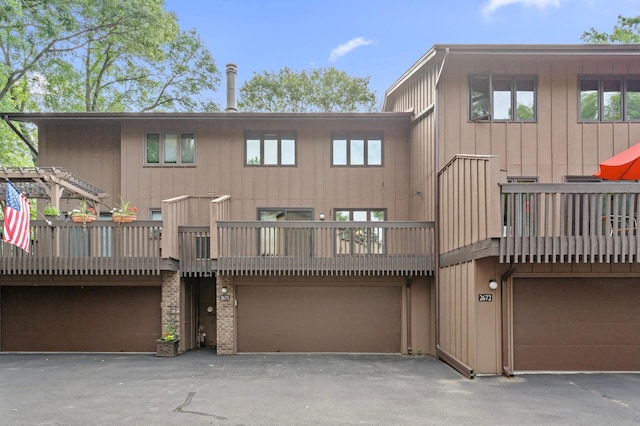 2671 Sumac Rdg, White Bear Lake, MN 55110 - rear view of house featuring an attached garage, driveway, a balcony, and board and batten siding