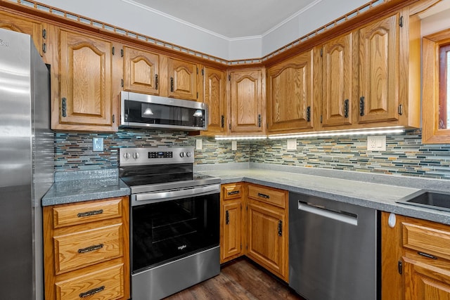 3820 8th St, Owatonna, MN 55060 - kitchen with stainless steel appliances, decorative backsplash, brown cabinetry, and ornamental molding