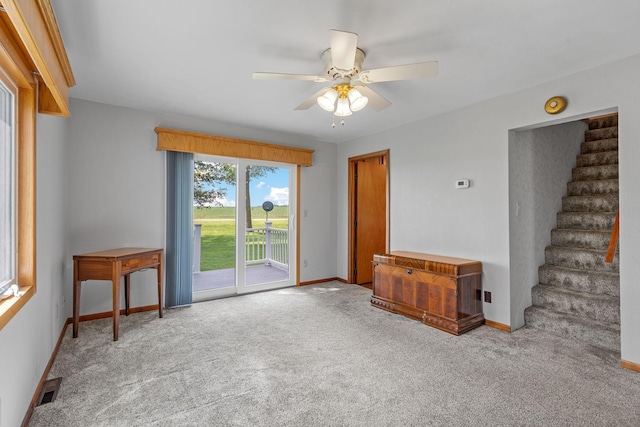 3820 8th St, Owatonna, MN 55060 - unfurnished living room featuring carpet flooring, stairs, and a ceiling fan