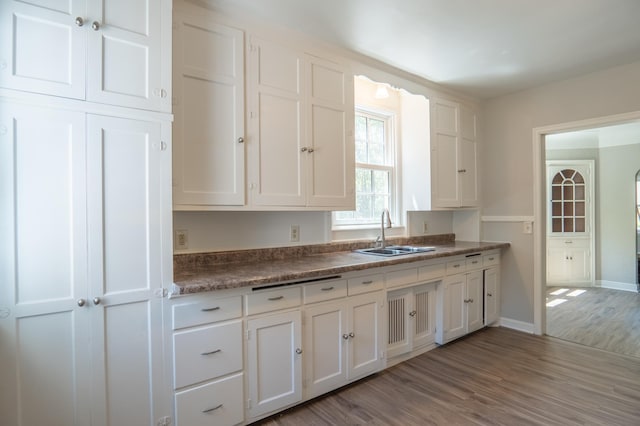 3410 Dupont Ave N, Minneapolis, MN 55412 - kitchen with white cabinetry, wood finished floors, and dark countertops