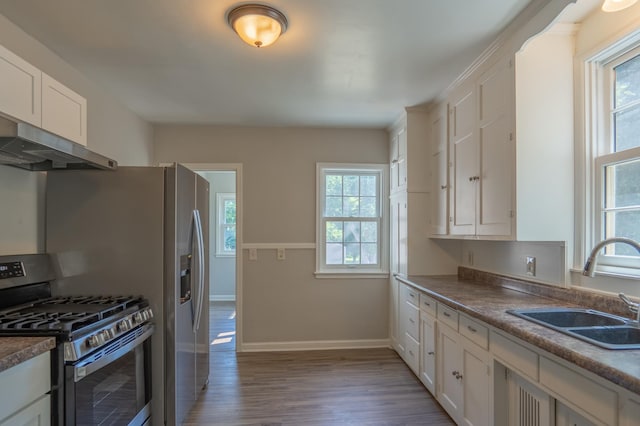 3410 Dupont Ave N, Minneapolis, MN 55412 - kitchen with stainless steel gas range, under cabinet range hood, wood finished floors, and healthy amount of natural light