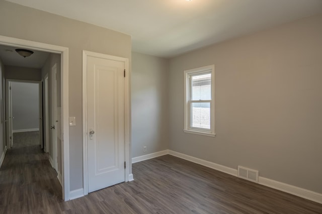 3410 Dupont Ave N, Minneapolis, MN 55412 - unfurnished bedroom featuring baseboards and dark wood-type flooring