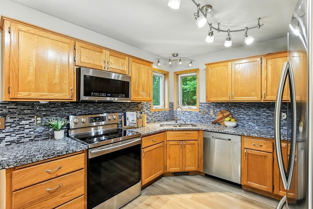 11883 Marigold Way, Lindstrom, MN 55045 - kitchen with appliances with stainless steel finishes, light wood-style floors, dark stone counters, and tasteful backsplash