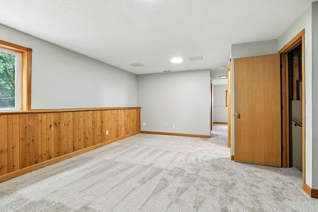 11883 Marigold Way, Lindstrom, MN 55045 - carpeted spare room featuring a textured ceiling, wooden walls, and a wainscoted wall
