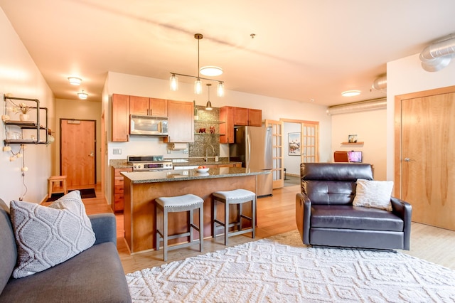 521 2nd St SE Unit 307, Minneapolis, MN 55414 - kitchen featuring appliances with stainless steel finishes, open floor plan, a breakfast bar area, and light wood finished floors