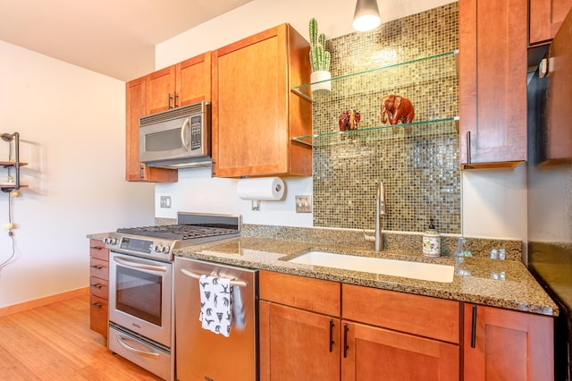 521 2nd St SE Unit 307, Minneapolis, MN 55414 - kitchen featuring appliances with stainless steel finishes, open shelves, light stone counters, light wood-style floors, and brown cabinets