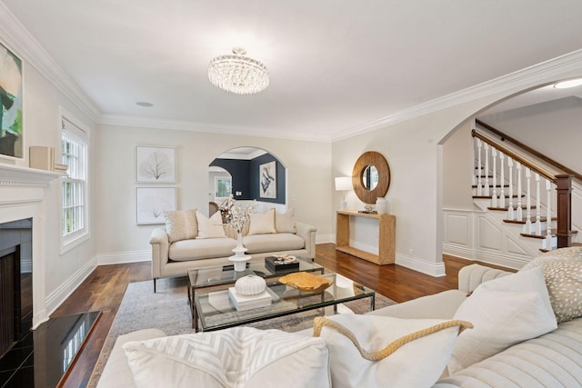 4622 Drexel Ave, Edina, MN 55424 - living room featuring arched walkways, a tiled fireplace, stairs, a chandelier, and ornamental molding