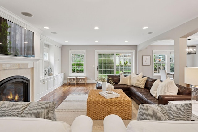 4622 Drexel Ave, Edina, MN 55424 - living area featuring wood finished floors, arched walkways, a glass covered fireplace, recessed lighting, and a chandelier