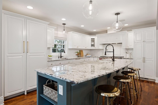 4622 Drexel Ave, Edina, MN 55424 - kitchen featuring white cabinets, dark wood-style floors, decorative backsplash, an island with sink, and recessed lighting