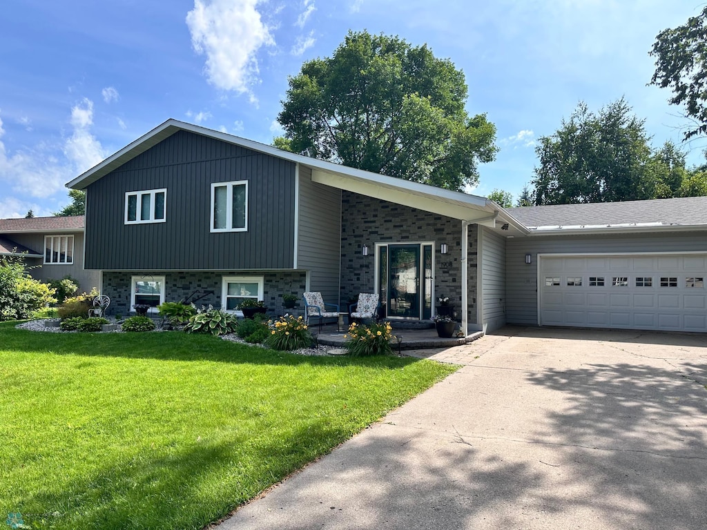 1908 23rd St S, Fargo, ND 58103 - tri-level home with a garage, concrete driveway, and a front lawn